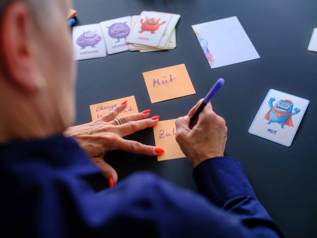 Nachdenkliche Mitarbeiterin in einem Meeting, während andere diskutieren – ein Sinnbild für inneren Rückzug und fehlende Beteiligung in Veränderungsprozessen.